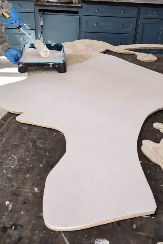 priming plywood cutout of Grinch