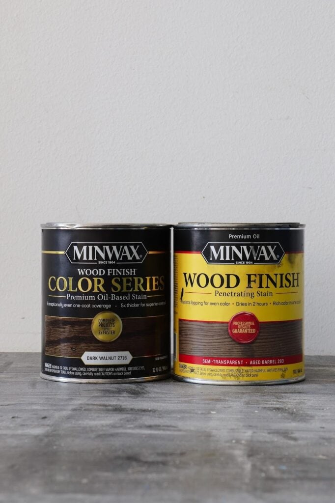 Oil-based stain cans - Minwax Wood Finish Colors Series in Dark Walnut next to Minwax Wood Finish Penetrating Stain in Aged Barrel