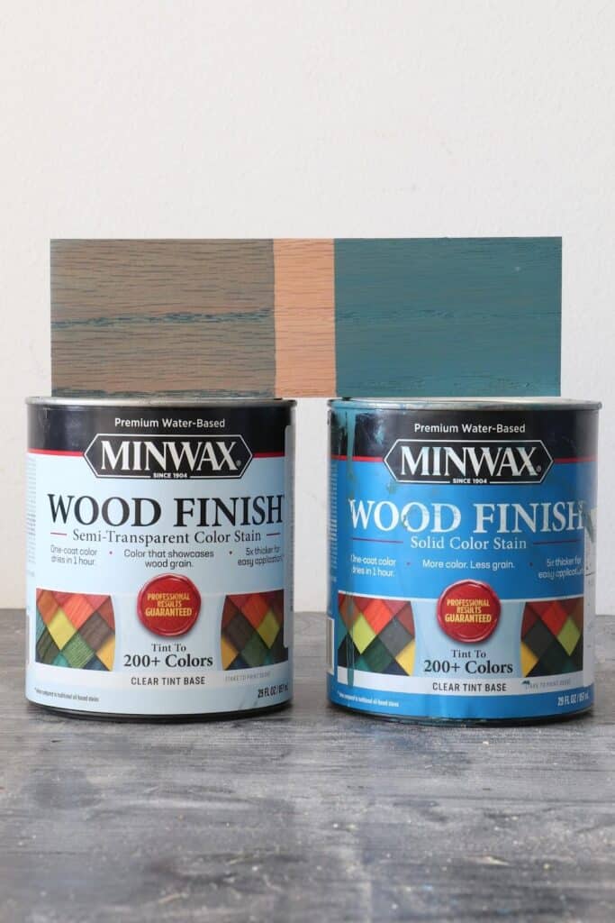 Minwax Semi-transparent color stain can next to Minwax Solid color stain can next to each other with a color sample of Bay Blue sitting on top to show the differences between semi-transparent and solid stain