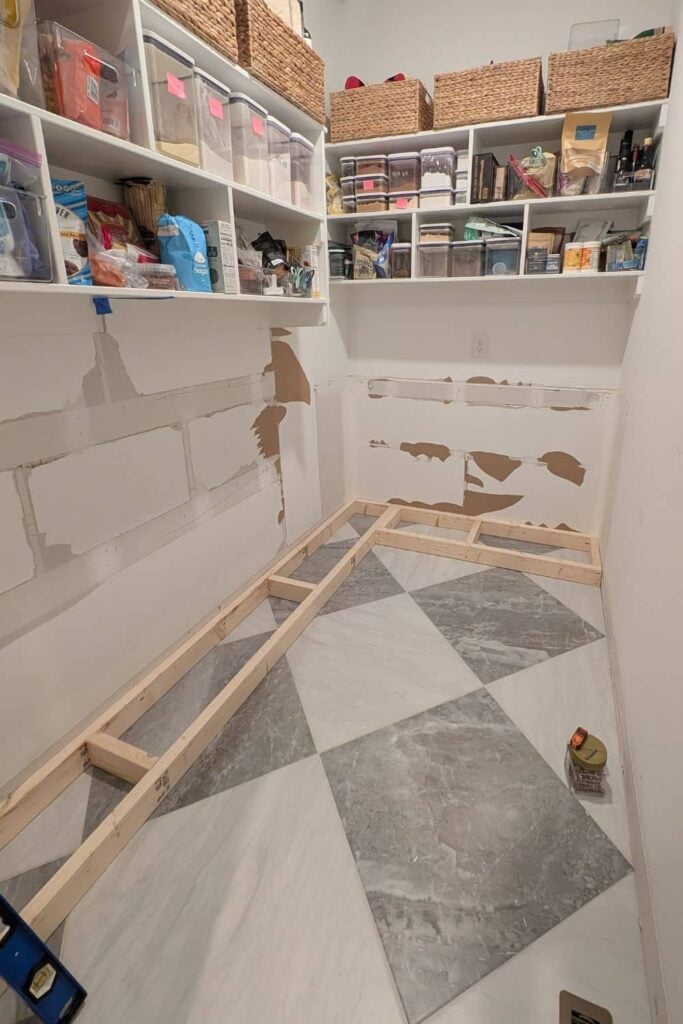 pantry being renovated with checked tile floors and lower cabinets removed