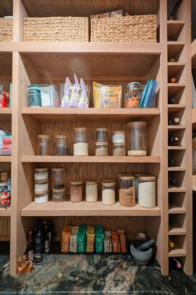 DIY pantry with glass and plastic organizing containers and a built-in wine rack